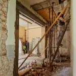 Un hombre subido en una escalera para reformar el baño